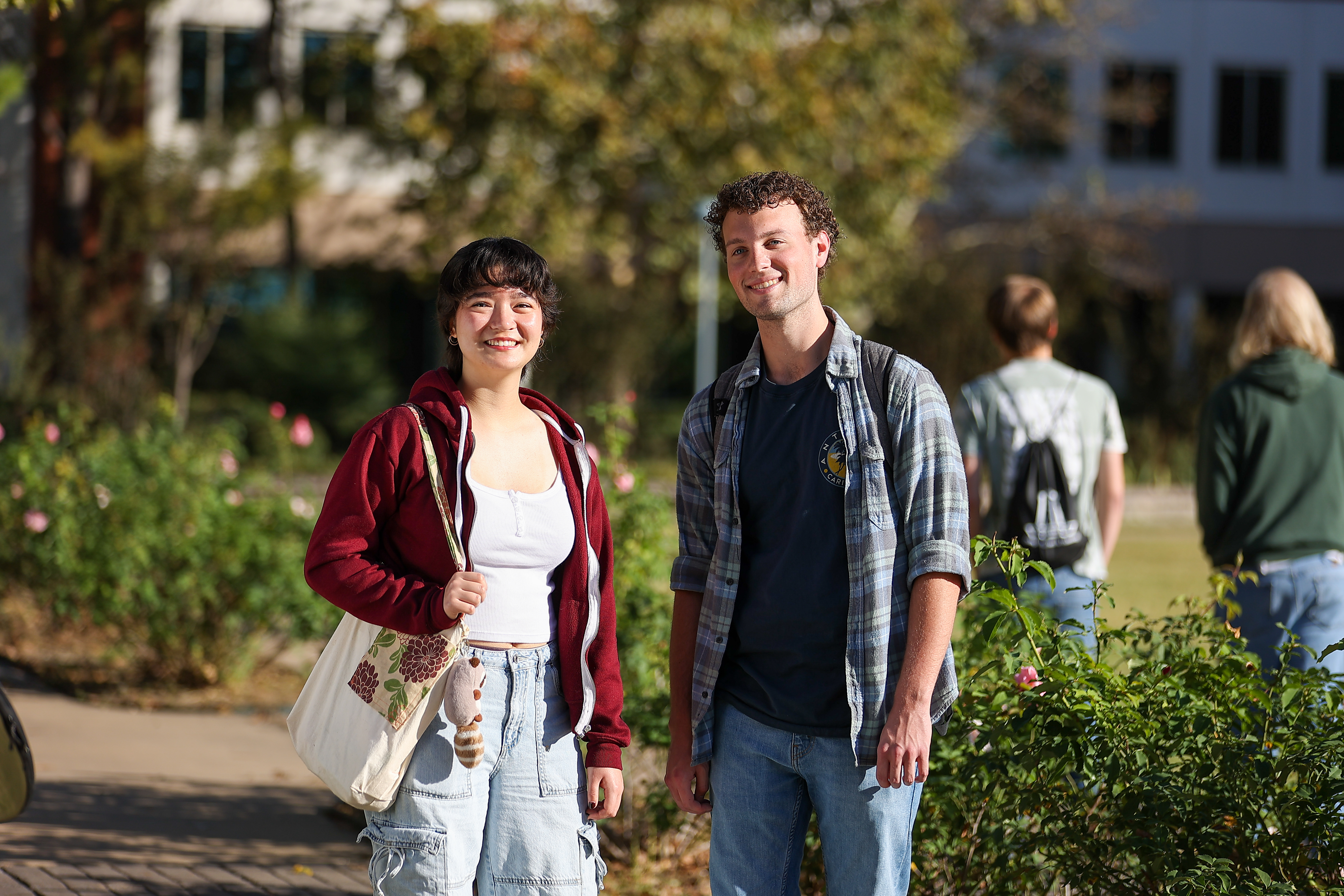 College students smiling on BA campus walkway