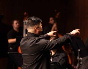 A photo of a conductor, leading the NSU Jazz Ensemble