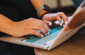 a picture of hands type on a laptop