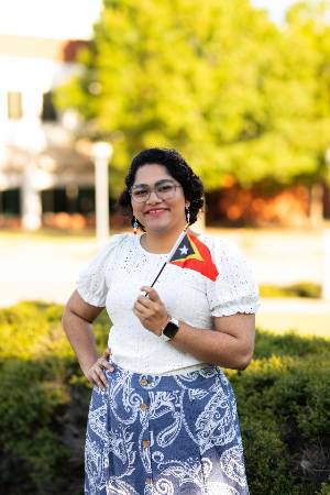 A shot of Thangam Varghese with a foliage background